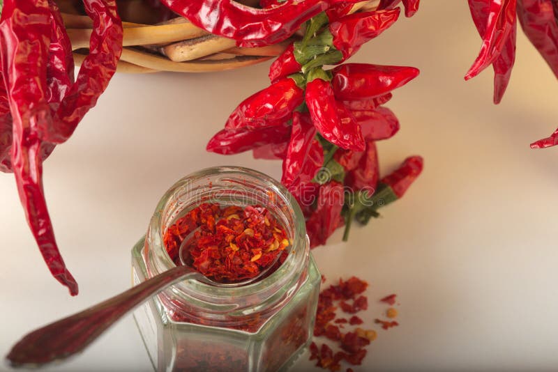 Spicy red pepper ground in the glass jar, with healthy dried peppers in the basket stock photo Spicy red pepper ground in the glass jar, with healthy dried peppers in the basket stock photo
