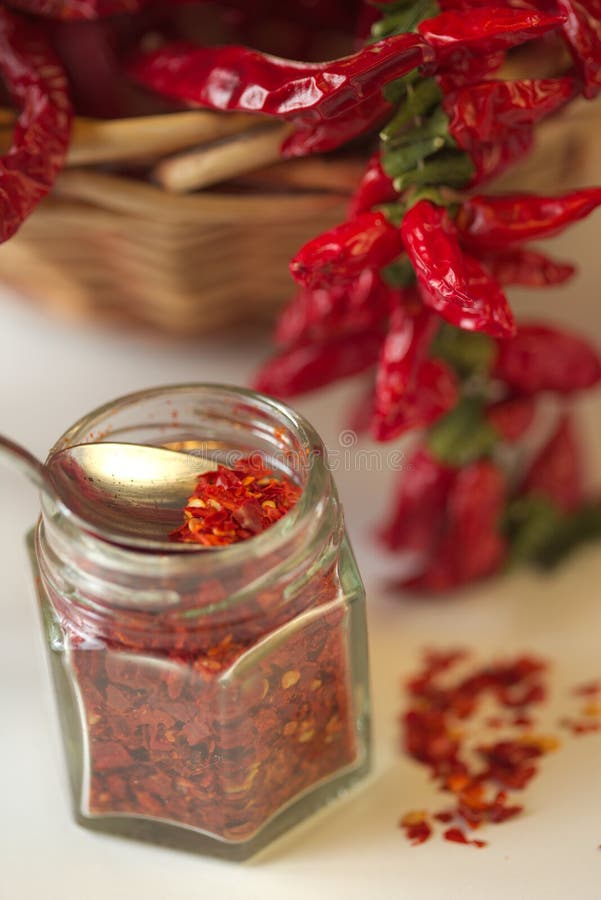 Spicy red pepper ground in the glass jar, with healthy dried peppers in the basket royalty free stock photography Spicy red pepper ground in the glass jar, with healthy dried peppers in the basket royalty free stock photography
