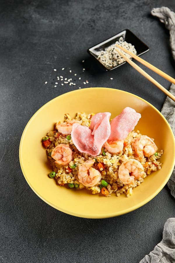 Spicy Shrimp Fried Rice with Vegetables. Yellow Plate with Wooden