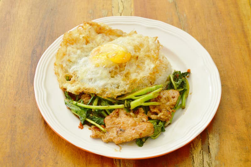 Spicy Stir Fried Chinese Kale with Pork Topping Egg on Rice Stock Image
