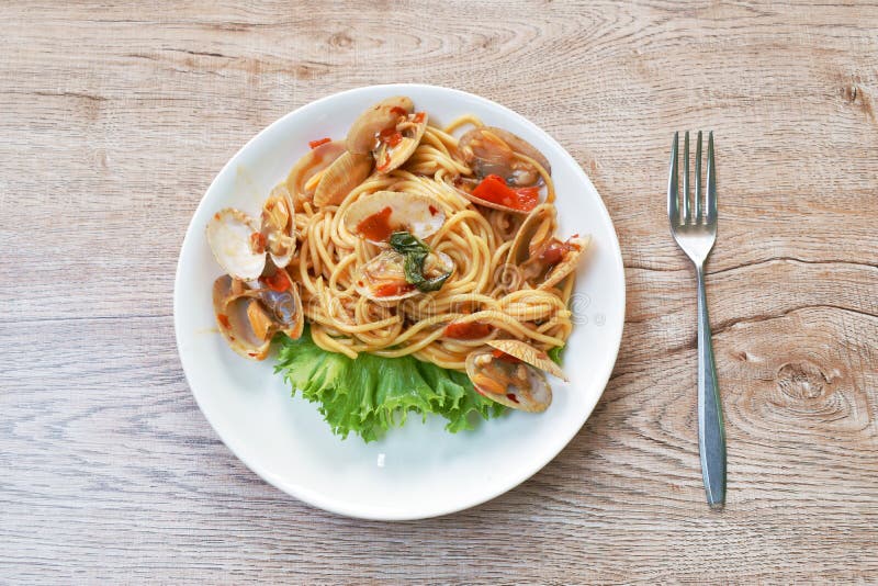 Spicy Stir Fried Spaghetti Clams with Pepper and Basil Leaf on Plate