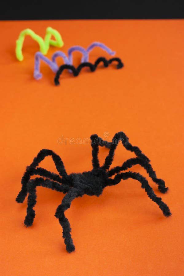 Black spider made of pipe cleaners on orange background. Halloween decoration, craft and fun concept. Black spider made of pipe cleaners on orange background. Halloween decoration, craft and fun concept.