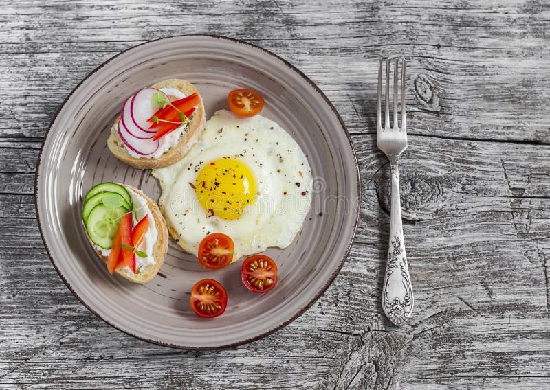 Spiegeleier, Tomaten und Sandwiche mit Gurke, Rettich und Weichkäse Auf einem hellen Holztisch Rustikale Art stockfotos Spiegeleier, Tomaten und Sandwiche mit Gurke, Rettich und Weichkäse Auf einem hellen Holztisch Rustikale Art stockfotos