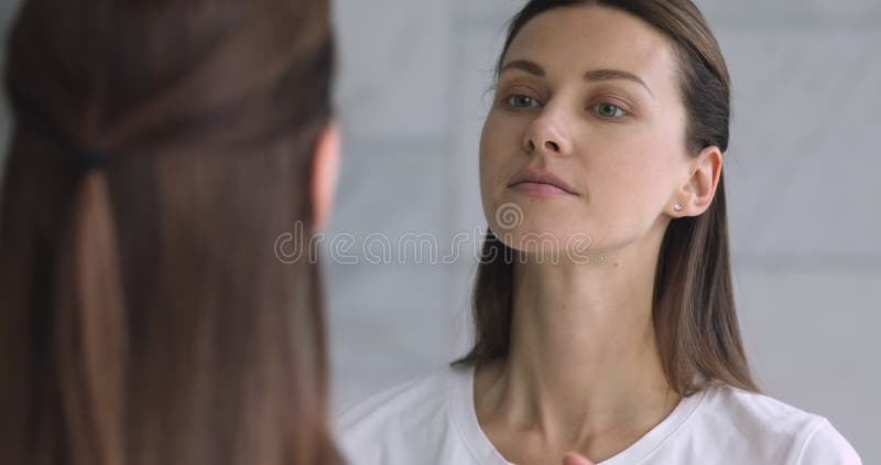 Spiegelreflectie aantrekkelijke jonge brunette vrouw die make - up maakt.