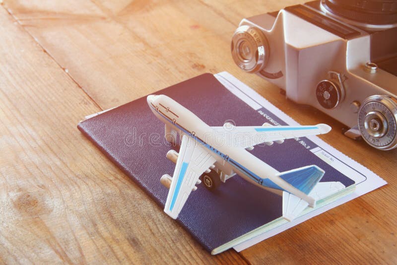 Spielzeugflugzeug und -paß über Holztisch lizenzfreie stockfotografie Spielzeugflugzeug und -paß über Holztisch lizenzfreie stockfotografie