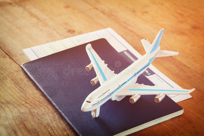 Spielzeugflugzeug und -paß über Holztisch Retro- Art-Bild stockfotos Spielzeugflugzeug und -paß über Holztisch Retro- Art-Bild stockfotos