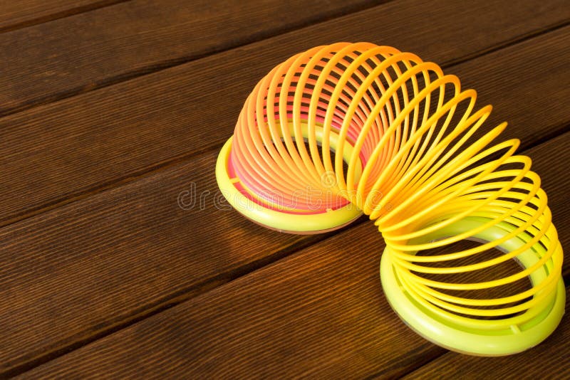 Spielzeugplastikregenbogen auf einem Holztisch Mehrfarbige Spirale für lizenzfreies stockfoto Spielzeugplastikregenbogen auf einem Holztisch Mehrfarbige Spirale für lizenzfreies stockfoto