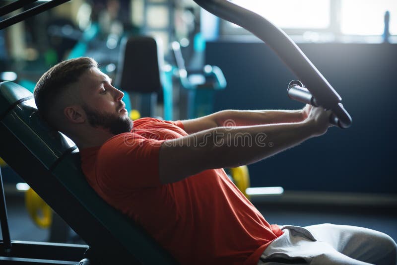 Spiermens die hard bij gymnastiek uitwerken Machineoefeningen Borsttrainingen royalty-vrije stock fotografie Spiermens die hard bij gymnastiek uitwerken Machineoefeningen Borsttrainingen royalty-vrije stock fotografie