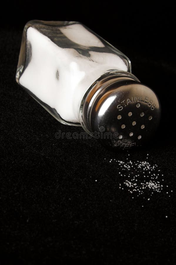Salt shaker on black with spilled salt. Kosher stock images, royalty-free photos and pictures