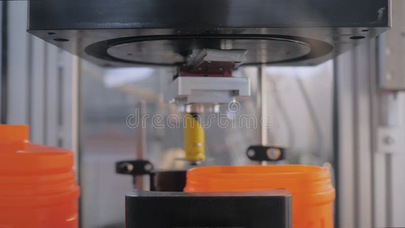 Spin dome trimmer cutting empty orange plastic jerrycans on conveyor belt stock video footage
