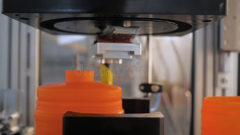 Spin dome trimmer cutting empty orange plastic jerrycans on conveyor belt stock video footage