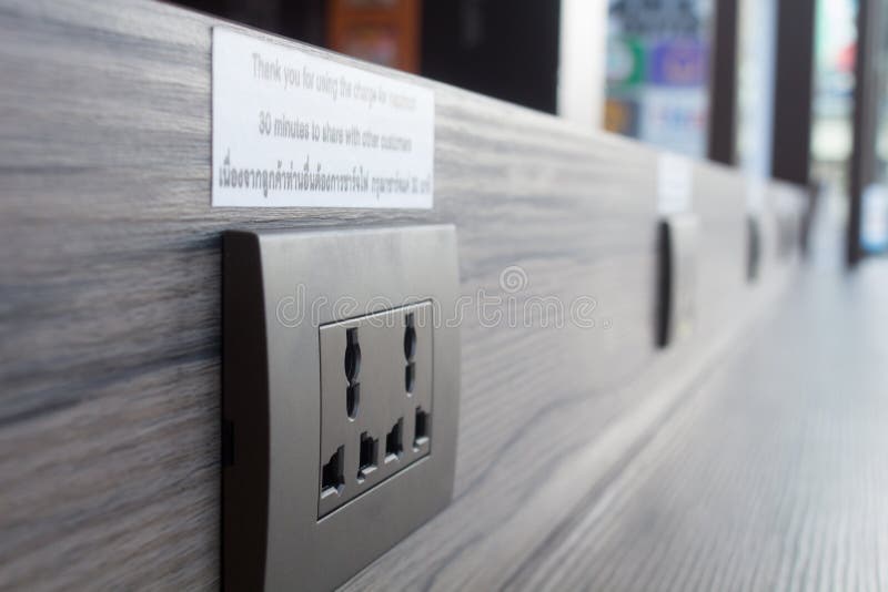 Spina di corrente per il telefono cellulare di carico in una caffetteria in Tailandia immagini stock libere da diritti Spina di corrente per il telefono cellulare di carico in una caffetteria in Tailandia immagini stock libere da diritti