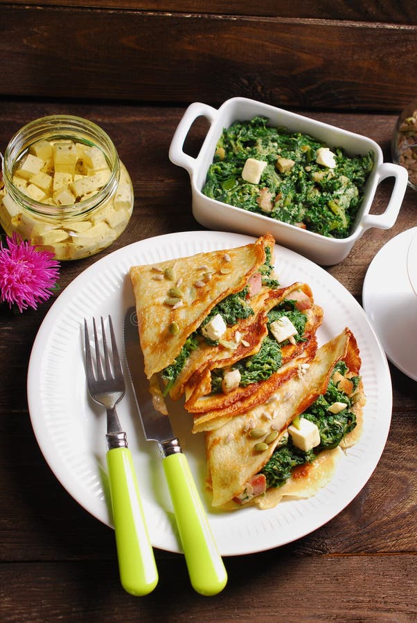 Spinat und Feta gefüllte Pfannkuchen auf Holztisch lizenzfreies stockbild Spinat und Feta gefüllte Pfannkuchen auf Holztisch lizenzfreies stockbild