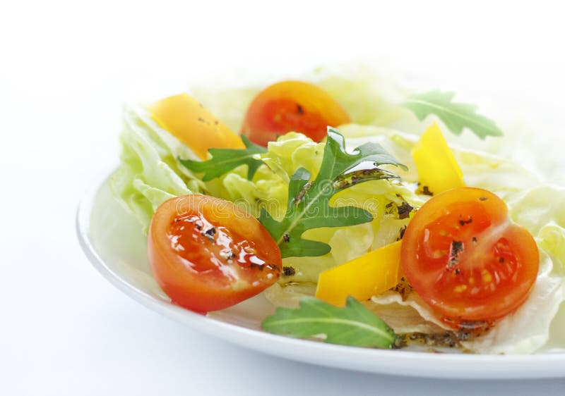 Sping salad mix with cherry tomatoes on a white plate