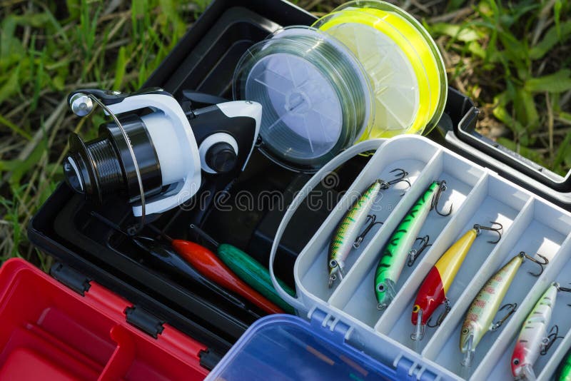 Spinnende Spule, Angelschnur, Plastikgeräte, künstliche Köder und andere Fischereiausrüstung des Hobbys stockbild Spinnende Spule, Angelschnur, Plastikgeräte, künstliche Köder und andere Fischereiausrüstung des Hobbys stockbild