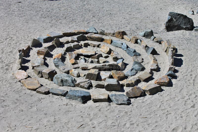 Spiral made with rocks on sand stock photography