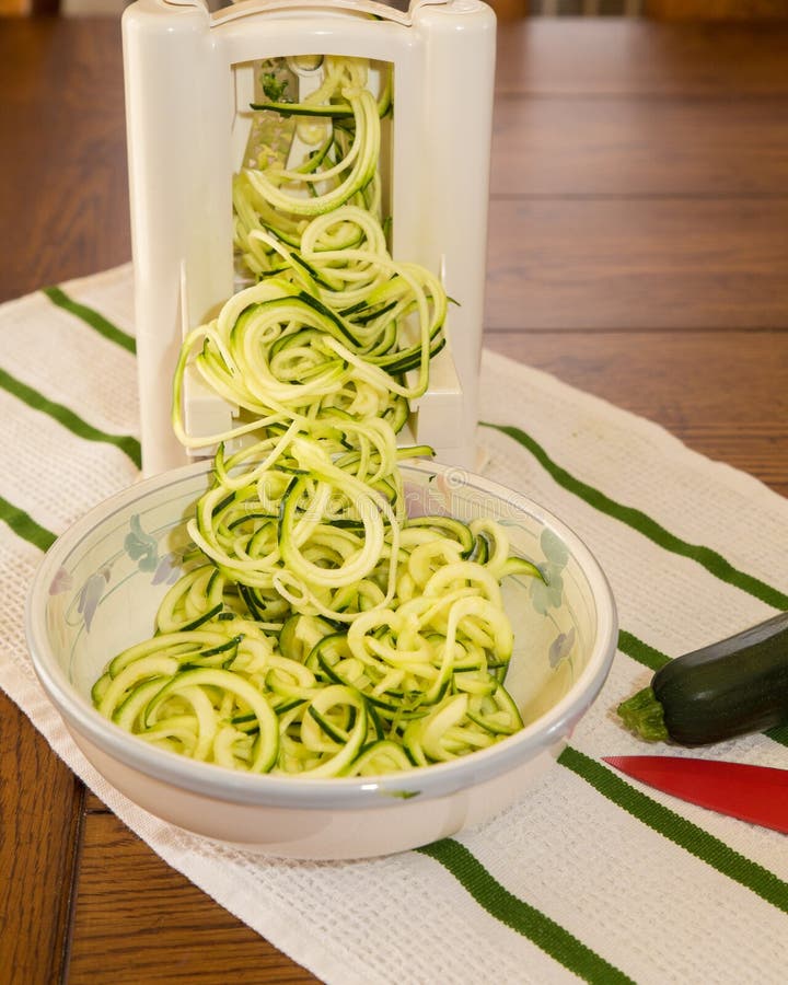 Making zucchini noodles with spiral vegetable slicer Stock Photo