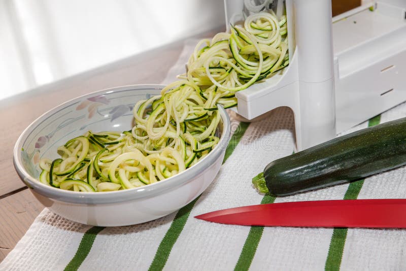 Making zucchini noodles with spiral vegetable slicer Stock Photo