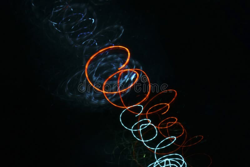 Spirales rougeoyantes de néon bleu et orange sur un fond noir illustration stock Spirales rougeoyantes de néon bleu et orange sur un fond noir illustration stock