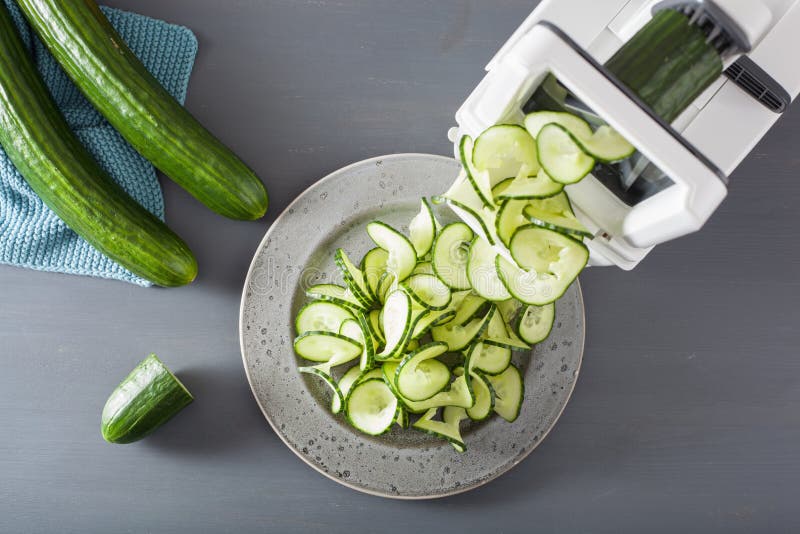 Spiralizing cucumber vegetable with spiralizer stock photography