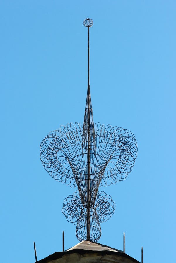 Spire on a rooftop of building with metal wire decoration