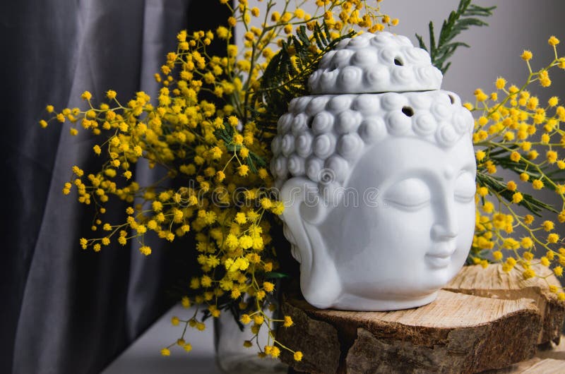 Spiritual ritual meditation face of Buddha on wood, home decor, mimosa yellow spring flowers