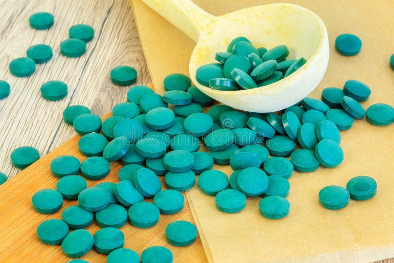 Spirulina minnestavlor nära träskeden royaltyfri foto Spirulina minnestavlor nära träskeden royaltyfri foto