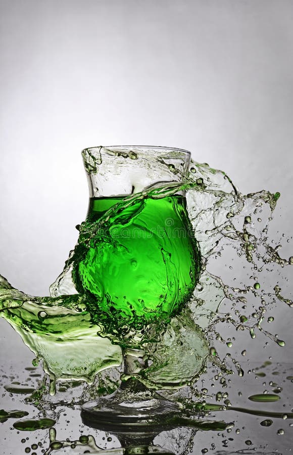 Splash in glass of green alcoholic cocktail drink