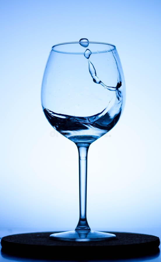 A Splash of Liquid in a Glass Wine Glass. Water Pouring Inside a Glass