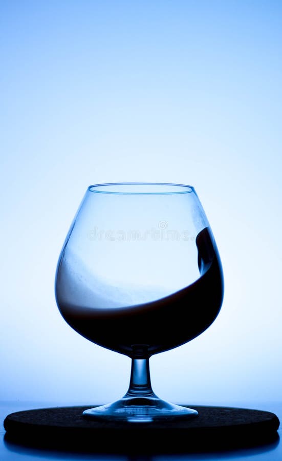 A Splash of Liquid in a Glass Wine Glass. Water Pouring Inside a Glass