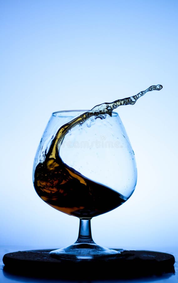A Splash of Liquid in a Glass Wine Glass. Water Pouring Inside a Glass