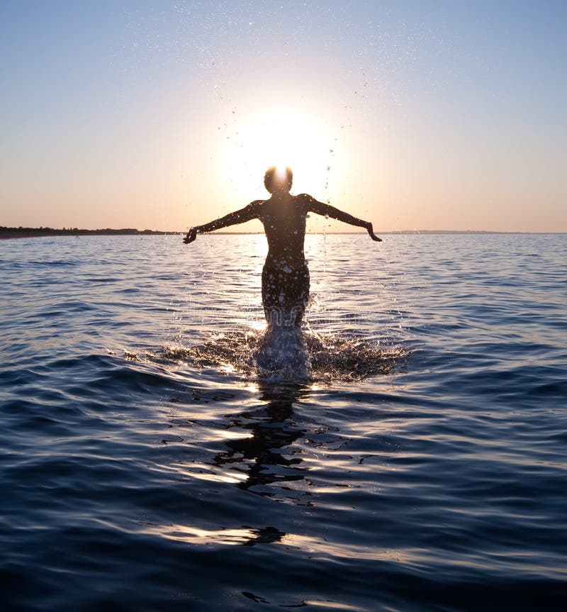 Swimmer jumping out of sea water on warm sunrise. Swimmer jumping out of sea water on warm sunrise