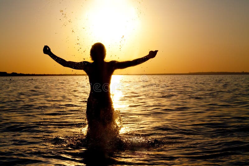 Swimmer jumping out of sea water on golden sunrise. Swimmer jumping out of sea water on golden sunrise