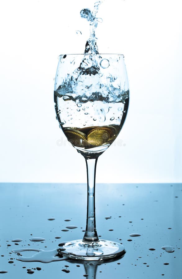 Splash of water and coins in a glass