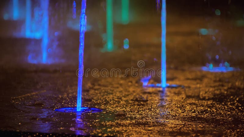 Splashes of colorful fountain. Water illuminated in diverse colors falling on a fountain which change its water color in.