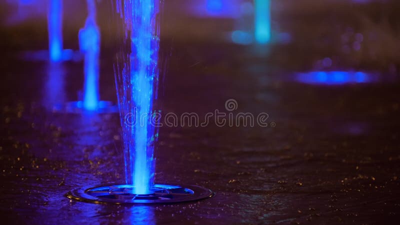 Splashes of colorful fountain. Water illuminated in diverse colors falling on a fountain which change its water color in.