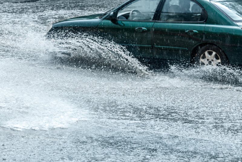 Splashes of Water from Car Wheels. Cars Driving in Heavy Rain. Stock