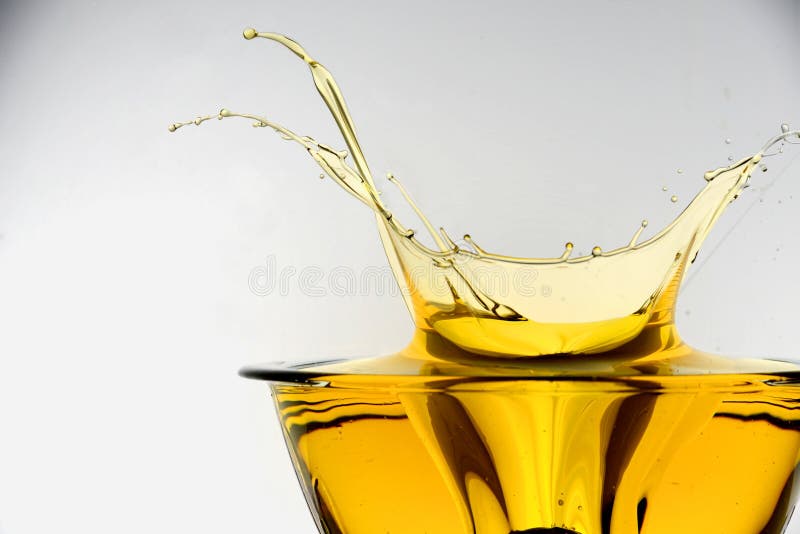 Side view of cooking oil splashing in container, studio background. Clear closeup view stock images, royalty-free photos and pictures