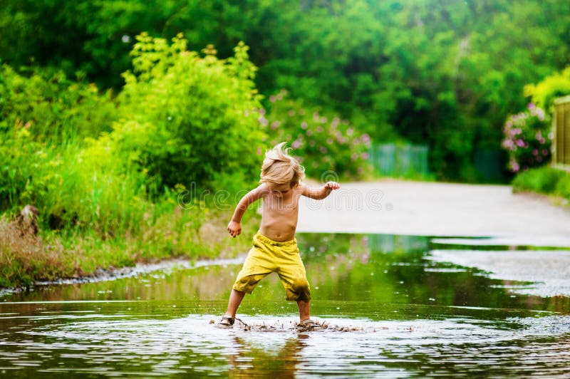 Little boy runs through a puddle. summer outdoor. Little boy runs through a puddle. summer outdoor