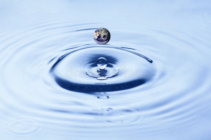 A closeup view of water droplets splashing into a puddle of water. A closeup view of water droplets splashing into a puddle of water.