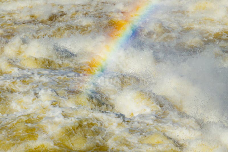 Splashing water waves with rainbow on the fast river stock photo