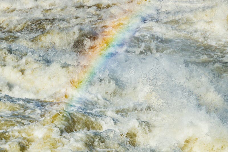 Splashing water waves with rainbow on the fast river stock images