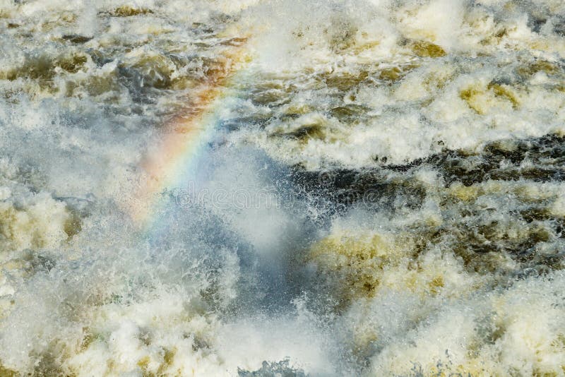 Splashing water waves with rainbow on the fast river stock photography