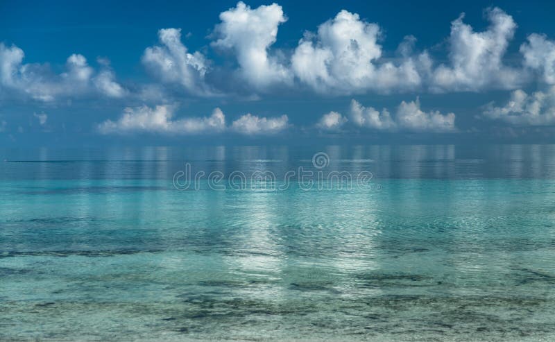 Splendid amazing inviting view of early morning ocean and white fluffy clouds reflected in water background