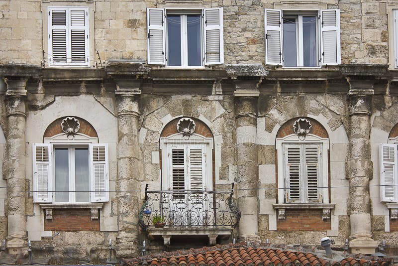 Close-up of the wall of an old house with beautiful windows stock photography