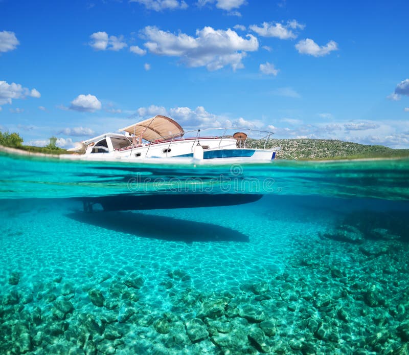 Split view - half underwater view of beautiful seabed with sea fishes and beautiful marine yacht, Turkey, Bodrum.