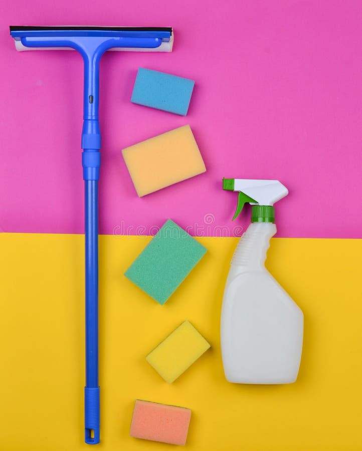 Sponges, window mop, sprinkler cleanser on a pink yellow background. Objects for home cleanliness. Products for cleaning royalty free stock photos Sponges, window mop, sprinkler cleanser on a pink yellow background. Objects for home cleanliness. Products for cleaning royalty free stock photos