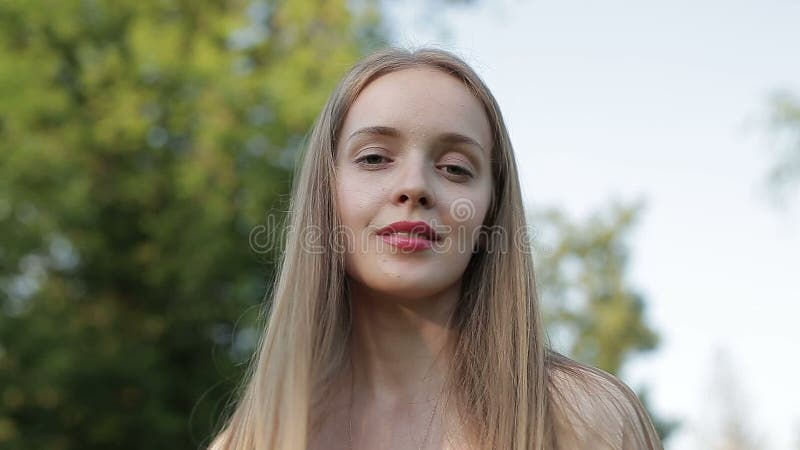 Spontane vrouwenglimlach die u met de wind die haar haar bewegen kijken