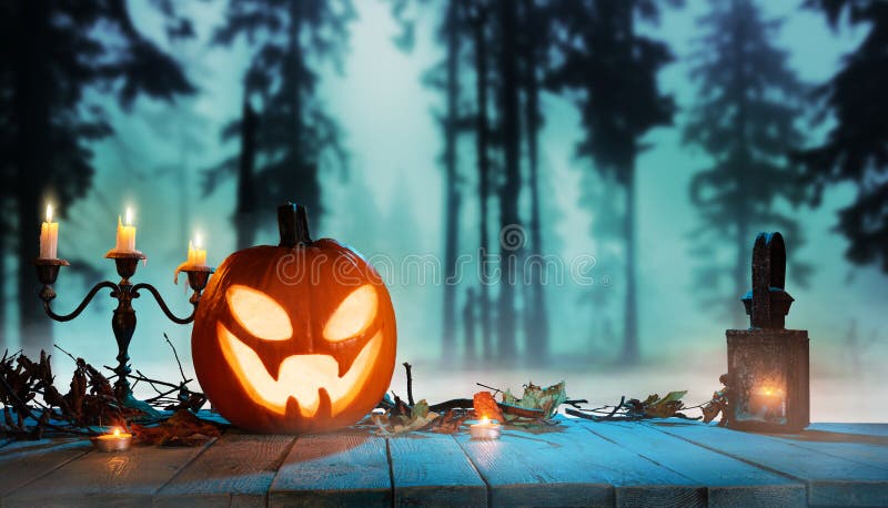 Spooky halloween pumpkin in forest. Scary halloween background with free space for text.