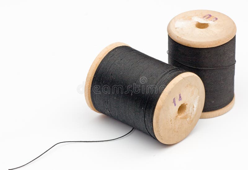 Black Thread on an Old Wooden Spool and Sewing Needle Stock